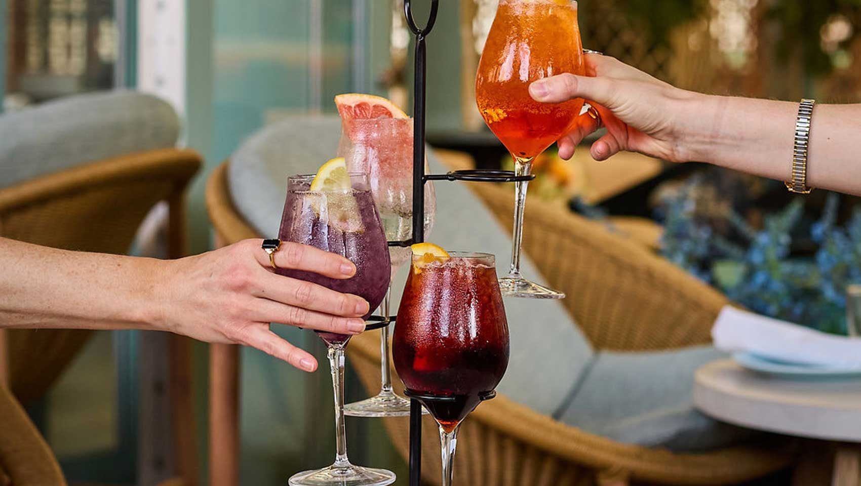 Colorful spritz cocktails served on a tiered stan